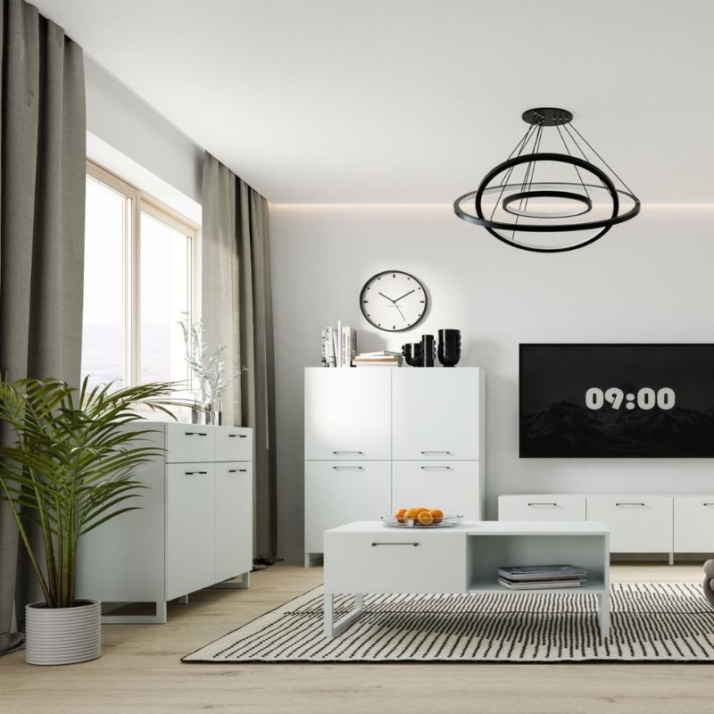 Modern living room with white furniture, a TV, and decorative items.
