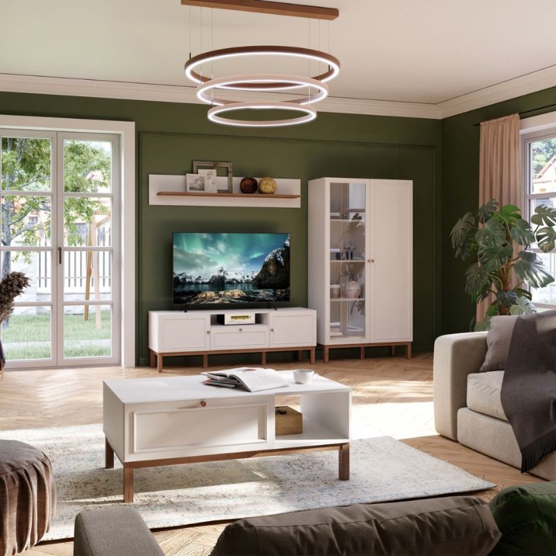 Modern living room with green walls, white furniture, and a TV.