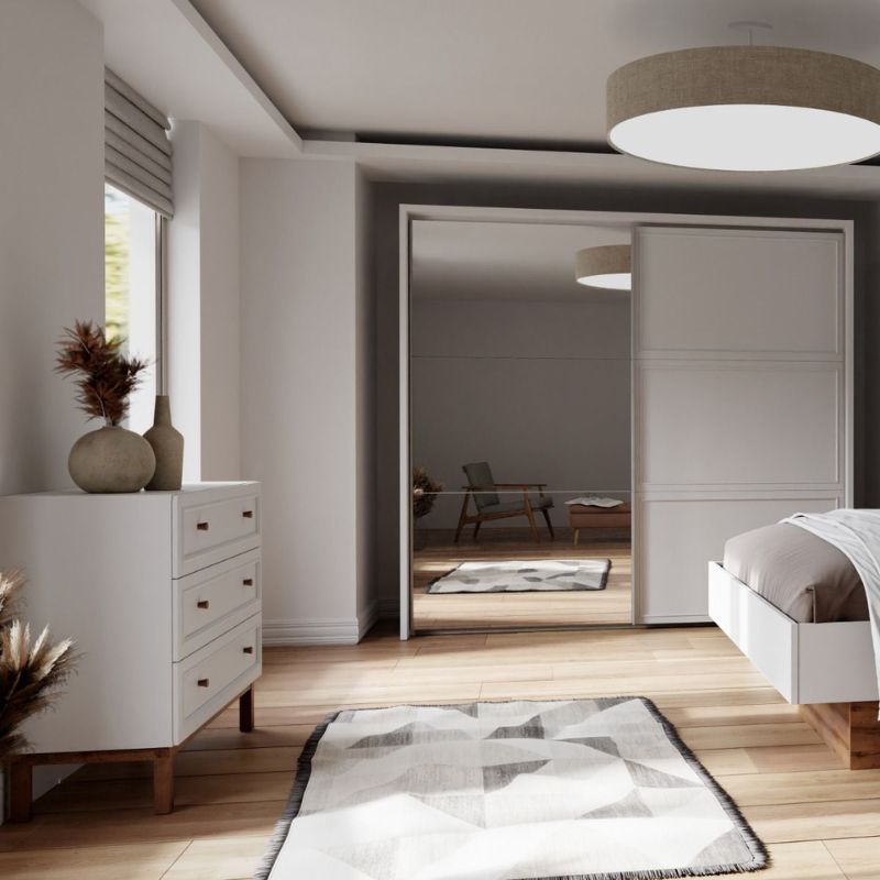 Modern bedroom with white furniture, wooden floor, and neutral decor.