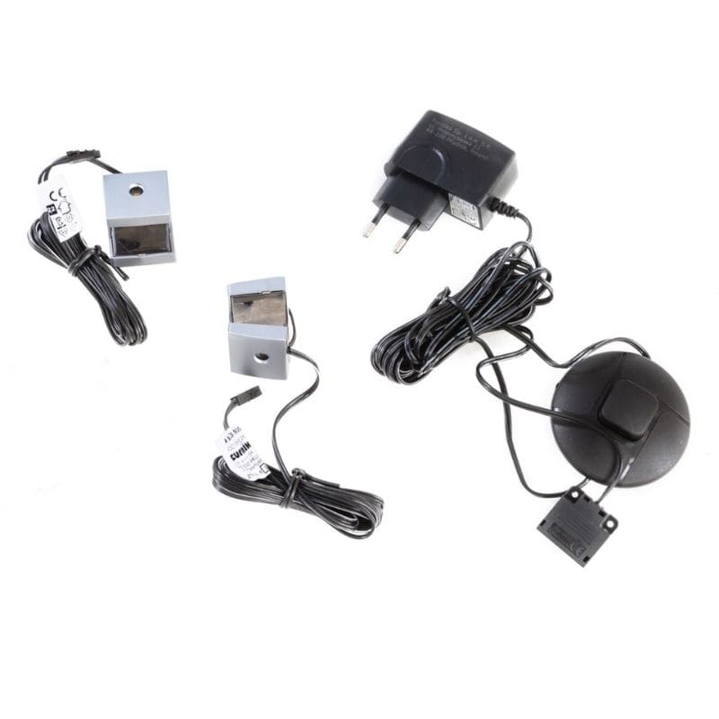 Set of electronic components including a power adapter, cables, and sensors on a white background