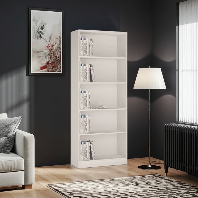 White bookshelf with books in a living room setting with a lamp and sofa.