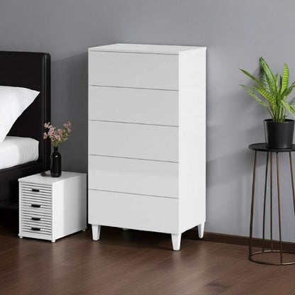 White dresser in a bedroom setting with a bed, nightstand, and plant.