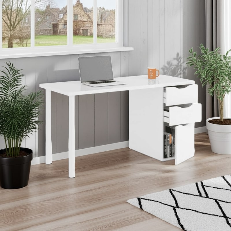 White office desk with laptop and mug in a room with plants and a window.