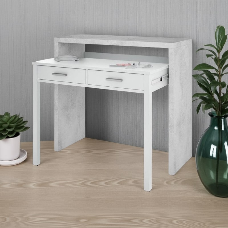 White desk with concrete finish on a wooden floor with decorative plants.