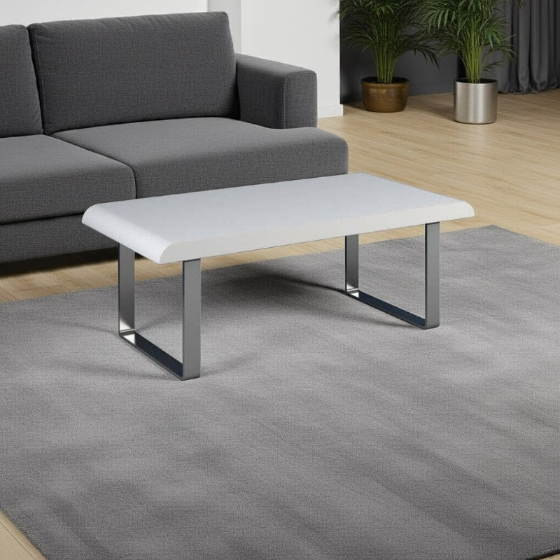 Modern coffee table with white top and metal legs in a living room setting.