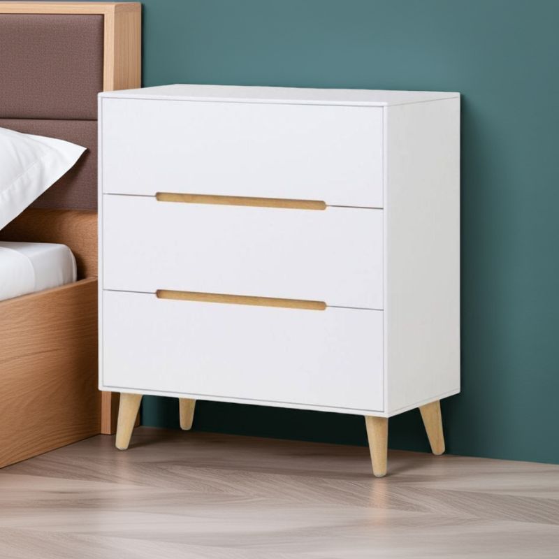 White dresser with wooden drawers against a teal wall