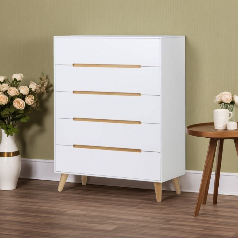 White dresser with wooden drawers in a room with a green wall and wooden floor.