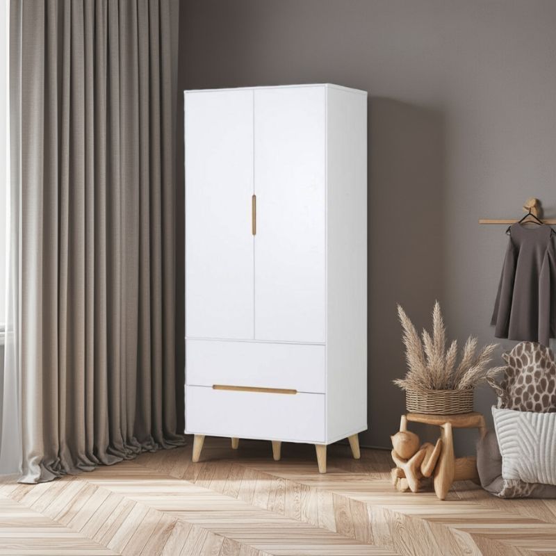 White wardrobe with gold accents in a room with curtains and decorative items.