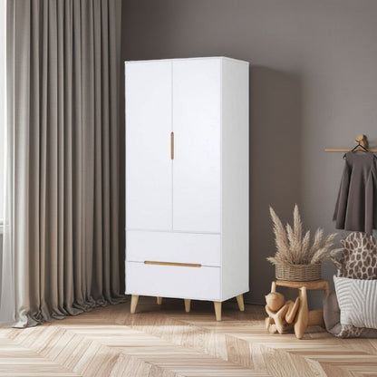 White wardrobe with gold accents in a room with curtains and decorative items.