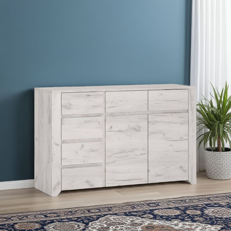White wooden sideboard against a blue wall with a plant and patterned rug.