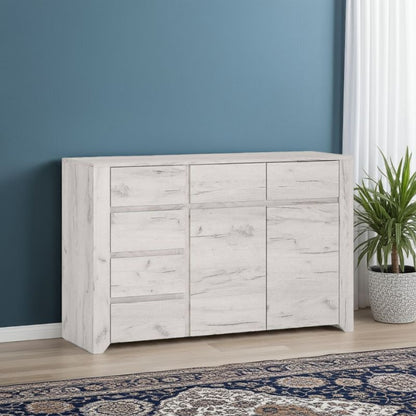 White wooden sideboard against a blue wall with a plant and patterned rug.