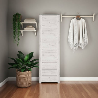White cupboard against a gray wall with a plant and hanging clothes in a room.