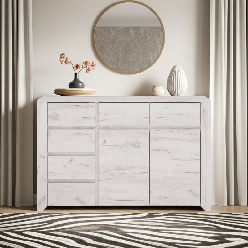 Light wooden sideboard with decorative items in a room with a mirror and curtains.
