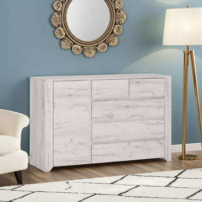 White wooden dresser against a blue wall with decorative mirror and lamp.