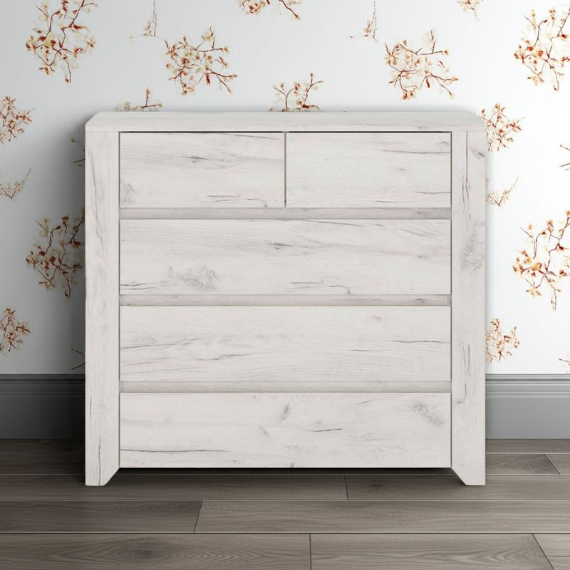White wooden dresser against a floral wallpapered wall