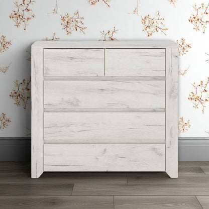 White wooden dresser against a floral wallpapered wall