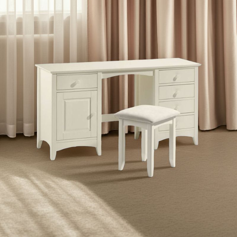 White desk with a cushioned stool in front of curtains