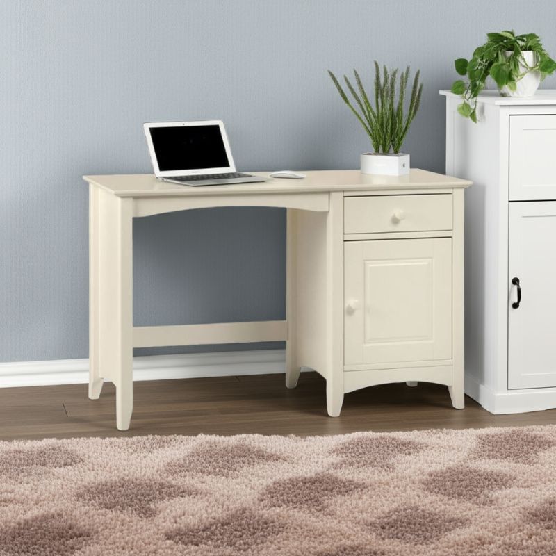White corner desk with laptop, plants, and cabinet in a room.