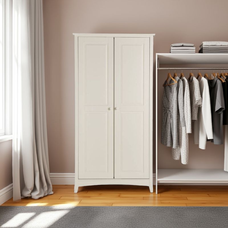 White wardrobe with clothes on a rack in a room with a window and curtains.