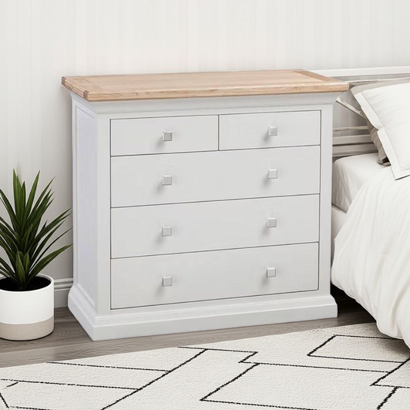 White dresser with wooden top in a bedroom setting