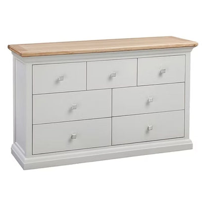 White dresser with six drawers and a wooden top on a white background