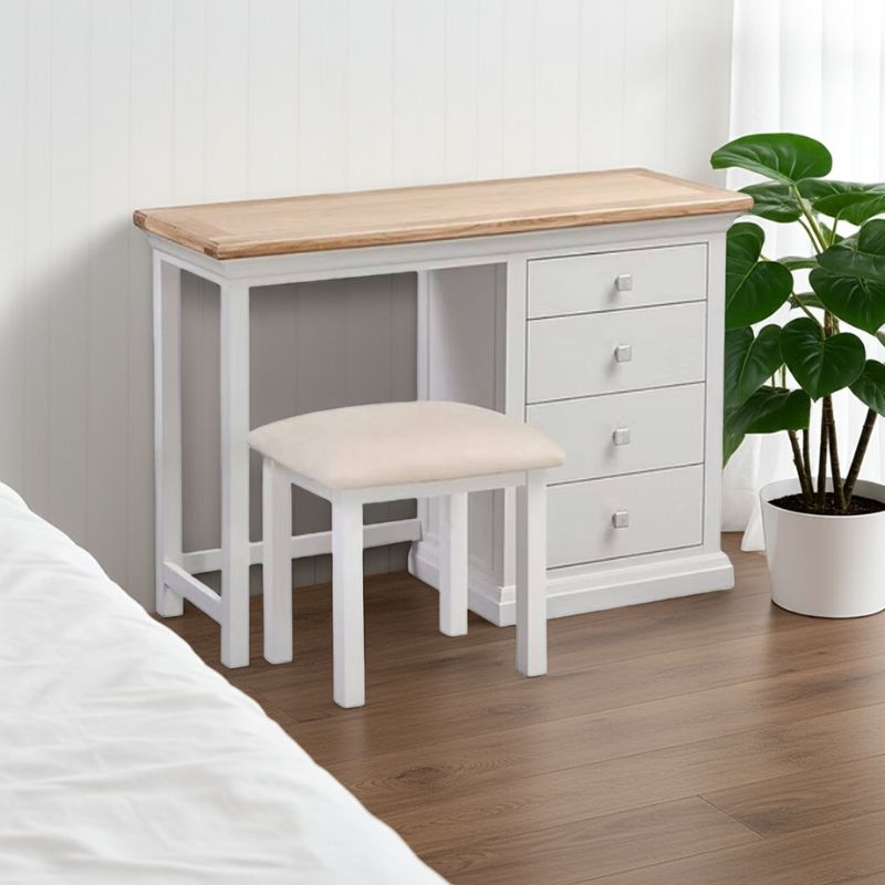 White desk with wooden top and beige stool in a bedroom setting