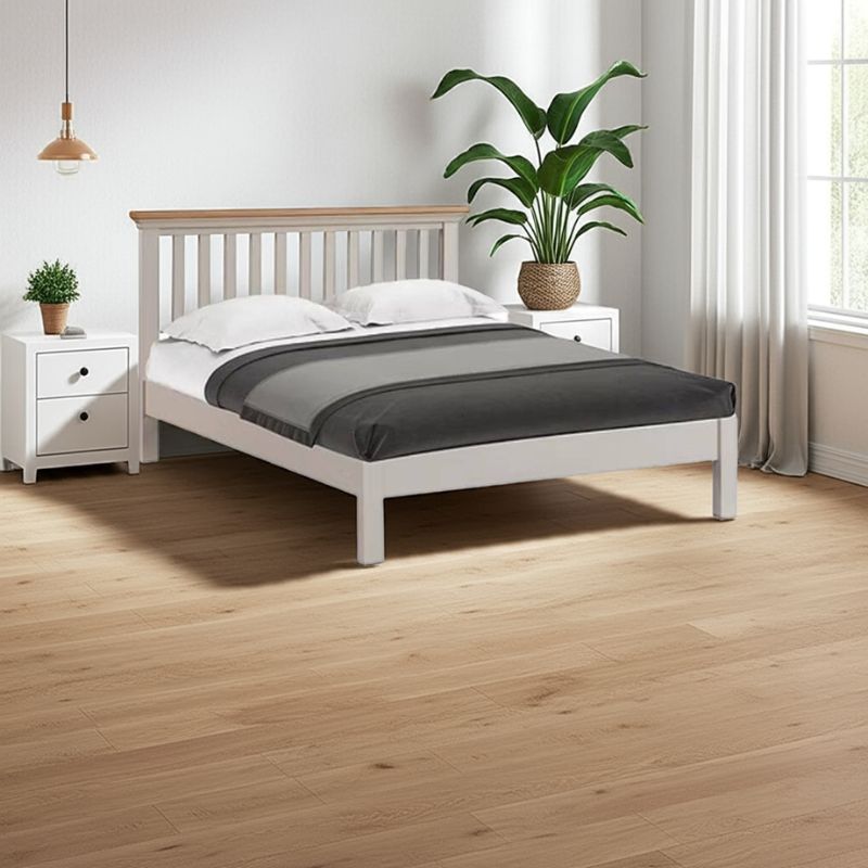 White bed with wooden headboard in a bedroom setting with plants and nightstands.