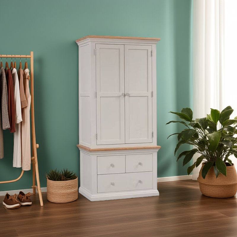 White wardrobe with wooden top and trim in a room with green walls, wooden floor, and plants.