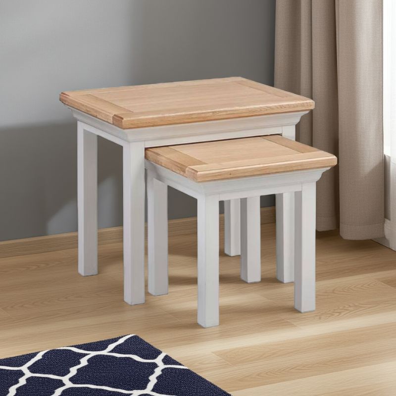 Two wooden nesting tables with white base on a wooden floor.