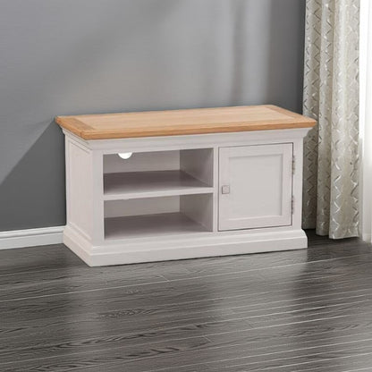White TV stand with wooden top in a room with gray walls and a curtain.