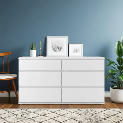 White dresser with framed pictures and plants against a blue wall