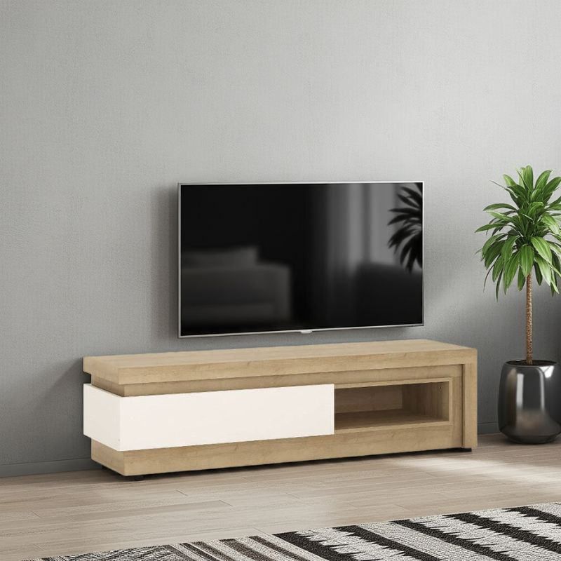Wooden TV stand with a television mounted on a gray wall, next to a plant.