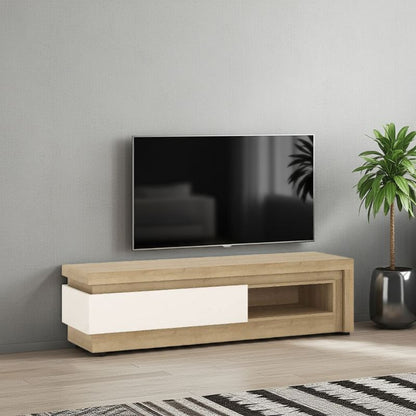 Wooden TV stand with a television mounted on a gray wall, next to a plant.