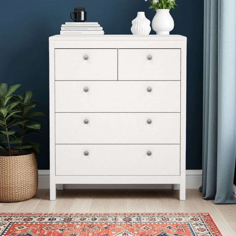 White dresser with decorative items against a dark blue wall