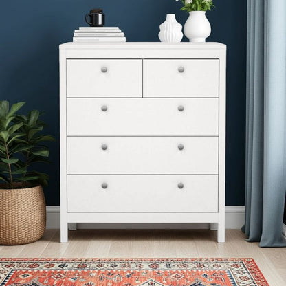 White dresser with decorative items against a dark blue wall