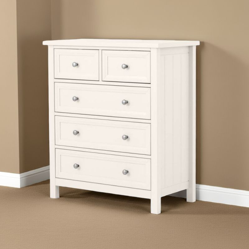White dresser with multiple drawers against a beige wall.
