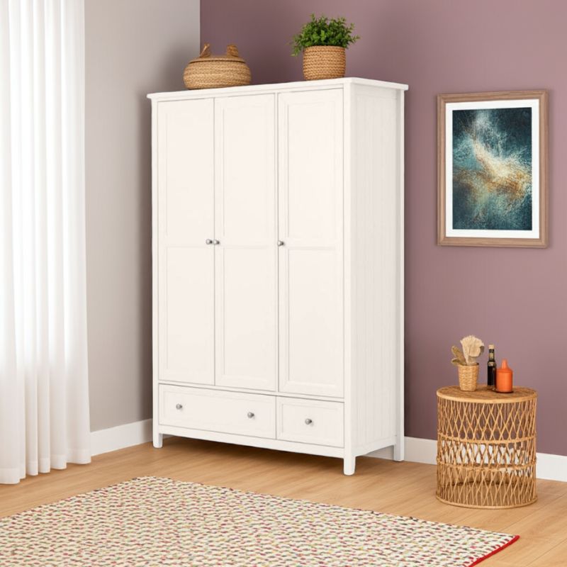 White wardrobe in a room with a purple wall, a small table, and decorative items.