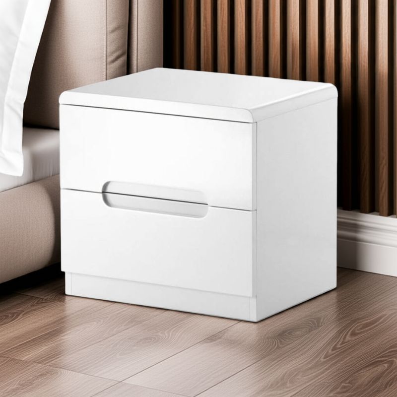 White nightstand with a drawer on a wooden floor next to a bed.