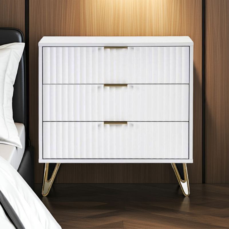 White nightstand with gold legs against a wooden wall