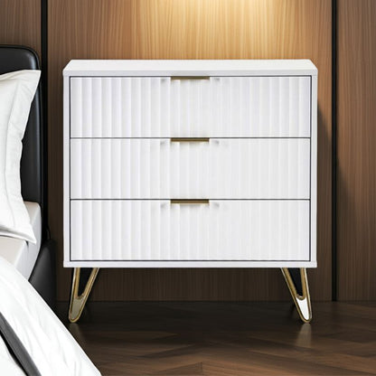 White nightstand with gold legs against a wooden wall