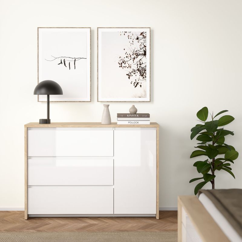 White dresser with wooden top in a room with framed art and a plant.