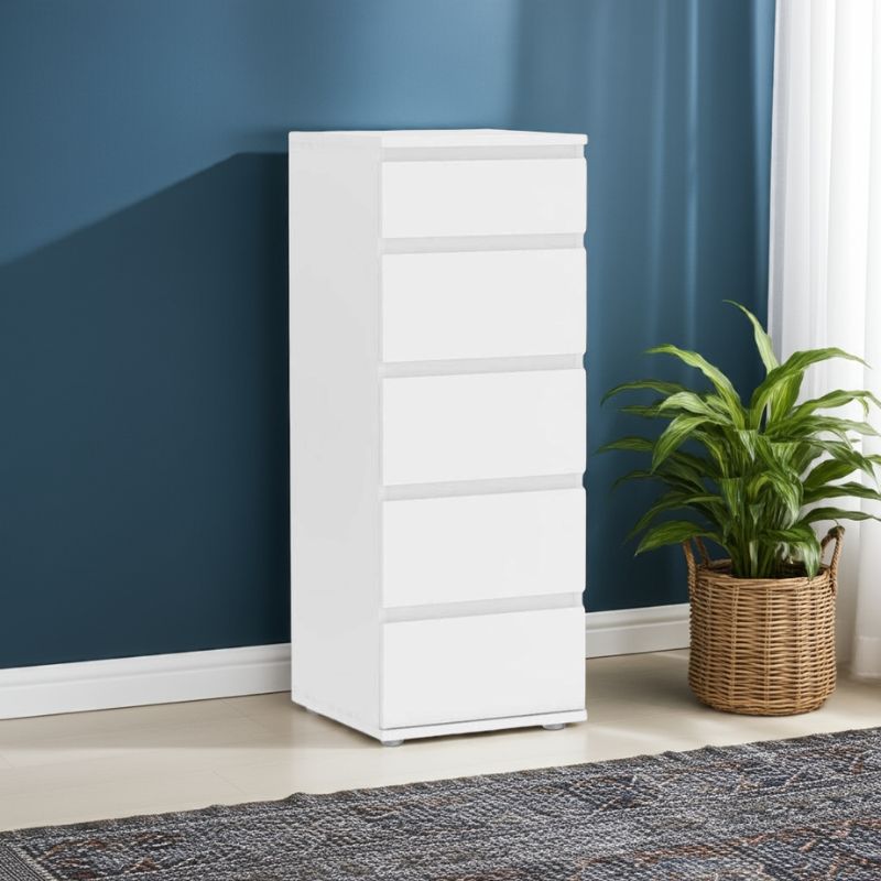 White dresser against a blue wall with a plant on a rug