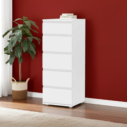 White dresser against a red wall with a plant on a wooden floor