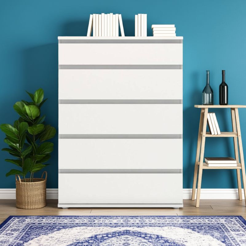 White dresser with 5 drawers against a blue wall with books and plants