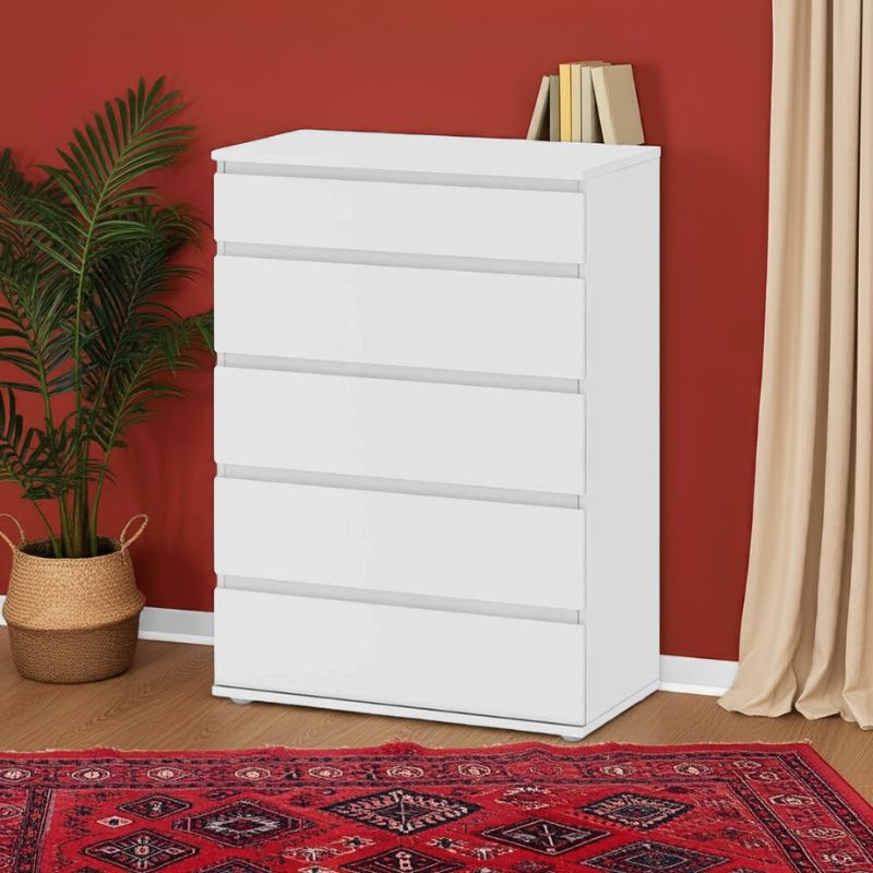 White dresser with books against a red wall with a plant and rug.