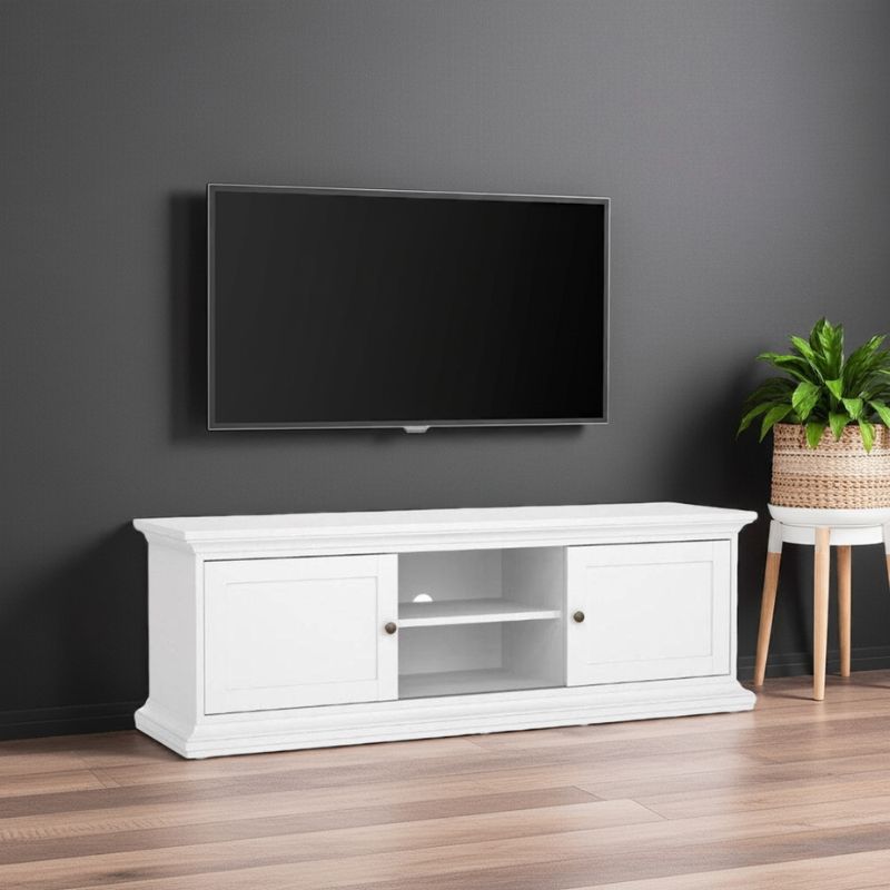 White TV stand with a mounted black TV against a gray wall, with a plant on a small table to the right.