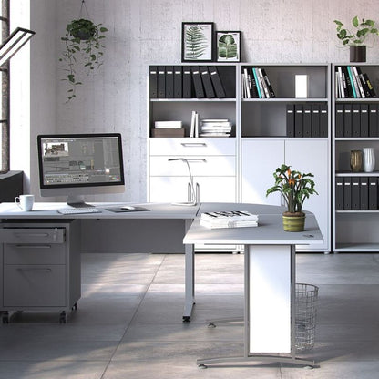 Modern office setup with a desk, computer, and white bookshelves.