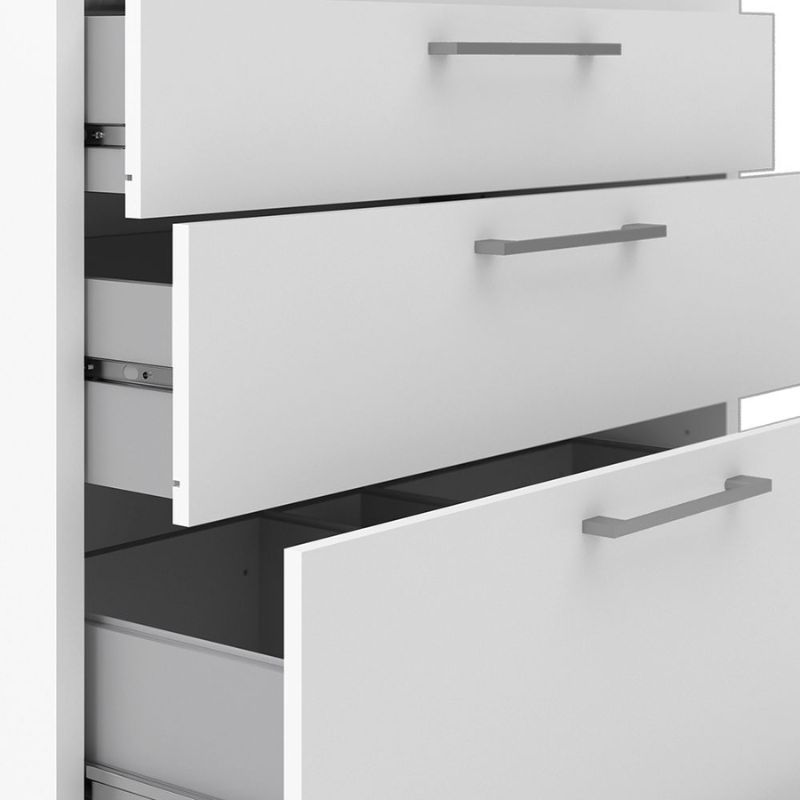 Close-up of a white cabinet with open drawers and a visible shelf.