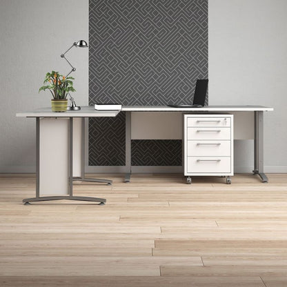 Modern office desk with a plant, lamp, and computer in a room with geometric wall design.