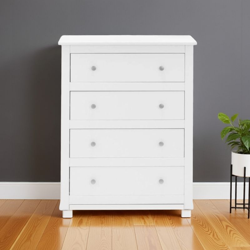 White dresser with three drawers against a gray wall with a plant on a shelf.